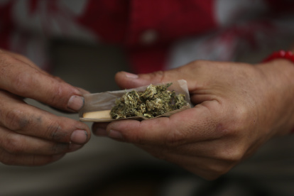 Fotografía de archivo de una persona que prepara un cigarro de mariguana.