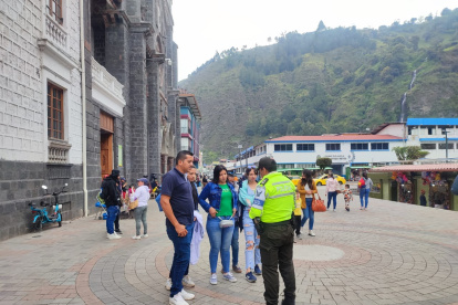 Medida. Un policía conversa con visitantes, en un sitio turístico.