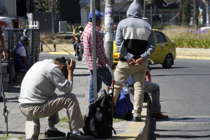 VARIAS PERSONAS ESPERANDO SOBRELA VEREDA DE UNA CALLE UN CONTRATO POR PARTE DE ALGÚN CONDUCTOR QUE NECESITE TRABAJADORES |