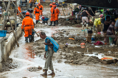 El desborde de ríos en Piura, debido a las intensas lluvias, ha dejado más de 300 familias evacuadas. Rescue workers clean up mud brought by the flooding caused by recent rains, in the province of Paita in Piura, northern Peru, on March 24, 2017. The El Nino climate phenomenon is causing muddy rivers to overflow along the entire Peruvian coast, isolating communities and neighbourhoods. / AFP / Ernesto BENAVIDES PERU-FLOODS