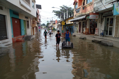 Situación. En el cantón Santa Lucía, la población debe hacer sus actividades cotidianas en medio de las calles inundadas.
