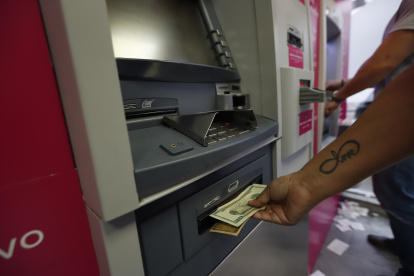 Tecnología.- Personas retirando dinero en cajeros automáticos.