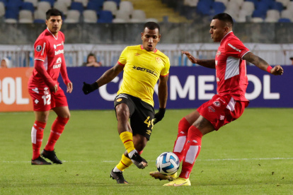 Juan Leiva (d) de Ñublense disputa el balón con Rómulo Otero de Aucas