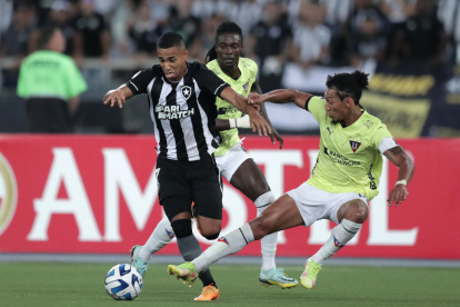 João Victor (i) de Botafogo y José Quintero de Liga de Quito disputan un balón.