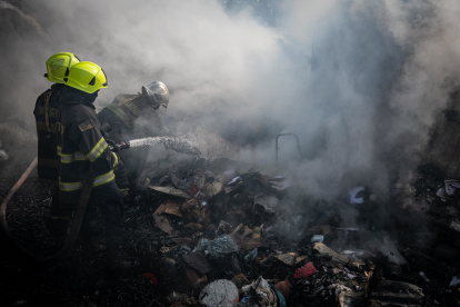 Los  bomberos tratan de sofocar las llamas en el mercado