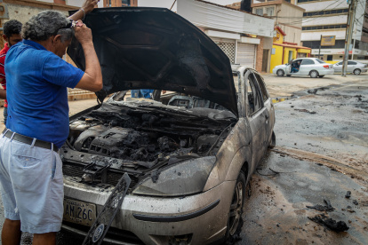 Un hombre observa un vehículo quemado en Maracaibo (Venezuela)