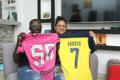 Silvia Alvarado y Grober Arroyo sostienen con orgullo las camisetas de su hijo Kenny Arroyo.
