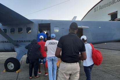 Fotografía cedida por el Ministerio de Seguridad Pública de Panamá de ciudadanos colombianos mientras abordan un avión para ser deportados a Colombia hoy.