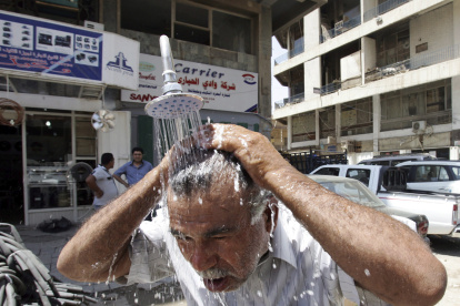 Un iraquí se refresca en una ducha pública en Bagdad (Irak) durante una ola de calor, en una imagen de archivo.