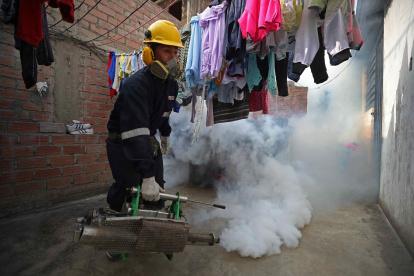 Un trabajador fumiga en una vivienda del distrito El Agustino como medida preventiva contra el dengue, en Lima (Perú). Foto de archivo.