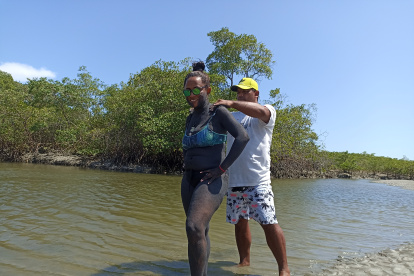 Muisne. En la isla Portete, el baño de arena negra es una tradición.