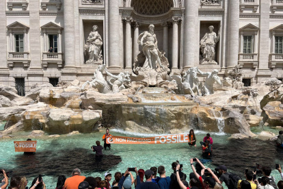 Rome (Italy), 21/05/2023.- Climate activists from the group "Last Generation" stand inside the Trevi Fountain in Rome, Italy, 21 May 2023. About a dozen activists, who recalled the emergency in the Italian region of Emilia-Romagna, where about 30,000 people have been displaced after heavy floods in recent days, threw a black liquid, vegetable charcoal, into the famed Trevi fountain with banners reading "let"s not pay for fossils" and shouting "our country is dying". Local police intervened on the spot. (Protestas, Inundaciones, Italia, Roma) EFE/EPA/GIULIA MARRAZZO