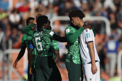Los jugadores de Nigeria consuelan a un rival de República Dominicana al finalizar el partido.