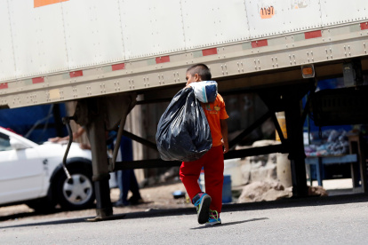 Un niño carga una bolsa negra donde lleva botes plásticos para reciclar en Olancho (Honduras), en una fotografía de archivo.