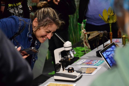 Una mujer observa a través de un microscopio durante el lanzamiento de la Semana de la Ciencia, este 23 de mayo de 2023 en Montevideo (Uruguay).