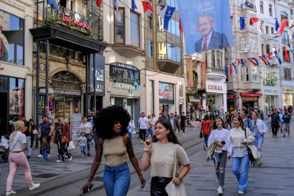La gente camina bajo un cartel de la campaña electoral del candidato presidencial turco Kemal Kilicdaroglu, líder del opositor Partido Popular Republicano (CHP), en la calle Istiklal en Estambul, Turquía, el 22 de mayo de 2023