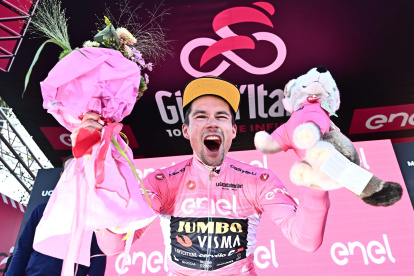 El ciclista esloveno Primoz Roglic (Jumbo Visma), con el jersey rosa, celebra en el podio tras vencer en la penúltima etapa y meterse líder en la general del Giro de Italia