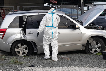 Un agente especializado revisa el vehículo en el que se movilizaba el agente de tránsito y un acompañante.
