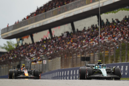 El piloto español de Aston Martin, Fernando Alonso (d), seguido por el mexicano de Red Bull, Sergio Pérez (I), durante el Gran Premio de España de Fórmula Uno, en el Circuito de Barcelona-Catalunya.