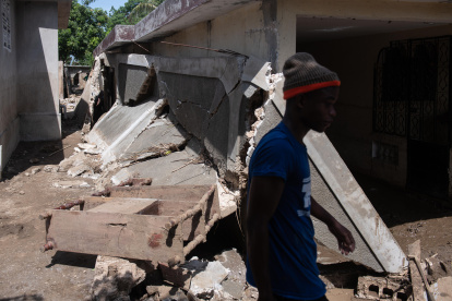 Un hombre camina junto a los escombros de una vivienda afectadas por graves inundaciones producto de las intensas lluvias, hoy, en Leogane (Haití). Los fuertes aguaceros registrados en Haití durante las últimas jornadas han dejado al menos 51 muertos.