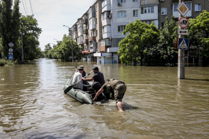Personas se mueven en un bote inflable por las calles de la inundada ciudad de Jerson, este miércoles 7 de junio.