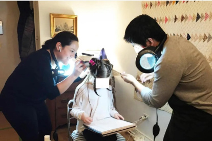 La ecuatoriana Eliana junto a un compañero de labores realiza el tratamiento contra la infestación de piojos de una niña en Nueva York.