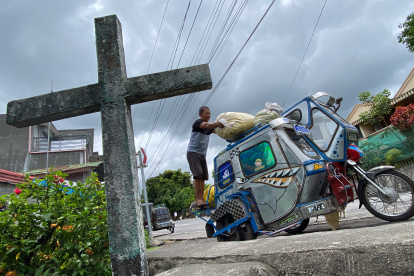 Un hombre mete sus pertenencias en su moto de tres ruedas durante la evacuación de las inmediaciones del volcán Mayón, al este de la isla filipina de Luzón,