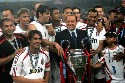Silvio Berlusconi, presidente del AC Milán, sostiene junto a sus jugadores el trofeo de campeones.