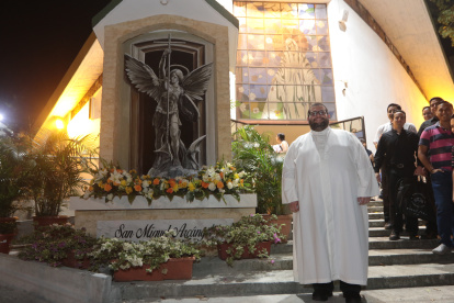 El padre Carlos Mena junto a la imagen de San Miguel.