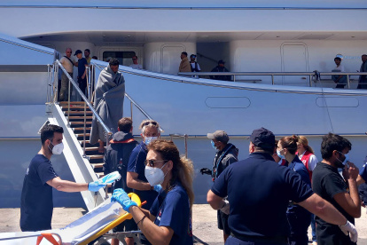 Paramédicos del Servicio Nacional de Ambulancias de Emergencia (EKAV) de Grecia y miembros de la Cruz Roja griega ayudan a los migrantes a su llegada al puerto de Kalamata, Grecia