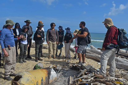 Los geólogos investigadores Felipe Lamus (d) y Nelson Rangel (2d) analizan junto a un grupo de colaboradores muestras recolectadas en las playas del Caribe colombiano, el 30 de mayo de 2023, en el marco de la investigación por la formación de rocas de plástico en el corregimiento de Galerazamba, departamento de Bolívar (Colombia). Rocas de plástico formadas por toneladas de residuos arrojados al mar que se derriten por el calor y se funden con los sedimentos naturales están alterando zonas costeras del Caribe colombiano donde crece la contaminación por este producto derivado del petróleo. EFE/Hugo Penso