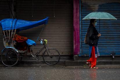una mujer caminando bajo la lluvia en Kathmandu (Nepal).