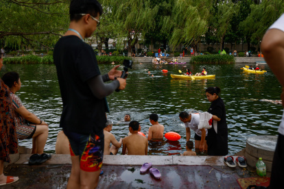 Beijing (China), 23/06/2023.- La gente se refresca a lo largo de un canal en Beijing, China, el 23 de junio de 2023. Beijing registró el 22 de junio el día más caluroso de junio con 41,1 grados centígrados