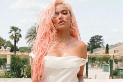 La artista lució un vestido blanco combinado con una mini cartera roja de Jacquemus que cuestan más de 1,300 dólares.