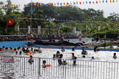 Un grupo de personas se refrescan en una psicina ante la ola de calor.