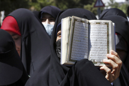Una mujer iraní sostiene un ejemplar del libro sagrado del Corán mientras se manifiestan frente a la embajada de Suecia en Teherán, Irán, el 30 de junio de 2023.