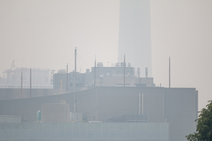 Fotografía de la icónica Torre CN (al fondo) prácticamente invisible debido al humo de los incendios forestales de la provincia de Quebec, este 30 de junio de 2023 desde una calle en el centro de la ciudad de Toronto (Canadá)..
