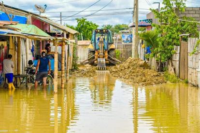 Proceso. Maquinaria intenta despejar una vía que no tiene asfalto.