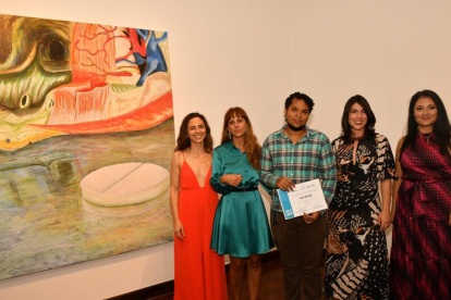 El guayaquileño Cristian Godoy, junto a su obra de arte ganadora del Salón de Julio 2022.