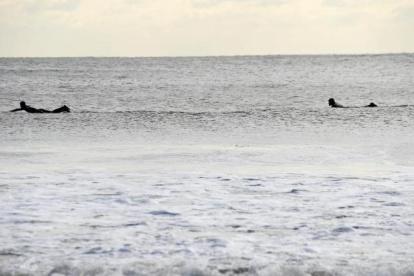 Imagen de archivo de surfistas nadando en la playa de Rockaway, New York.