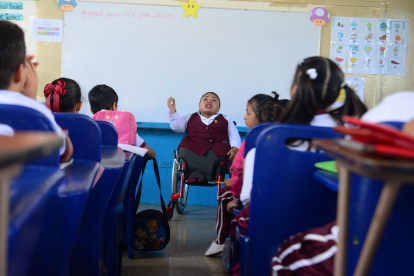 Dedicación. Sobre su silla de ruedas, la maestra Clara Celi imparte enseñanza a los estudiantes de la escuela fiscal Benjamín Rosales.