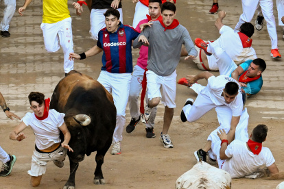 Un mozo es arrollado por uno de los toros de la ganadería de Fuente Ymbro en su entrada a la plaza de toros de Pamplona, el lunes 10 de julio.