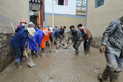 Moradores de la aldea de limpian los escombros de un deslizamiento de tierra en una zona de Zhangzigou.