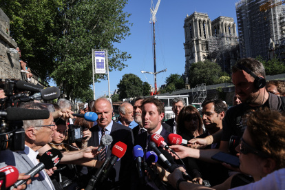 El ministro francés de Transporte, Clement Beaune (d) y Jean-Louis Georgelin, quien supervisa la reconstrucción de Notre Dame, hablan con los medios.