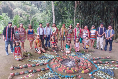 Un grupo de personas aparecen rodeando una instalación tradicional en la nacionalidad Tsa"chila.