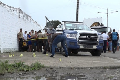 Agentes de Criminalística recogiendo indicios en un sector de Naranjal.