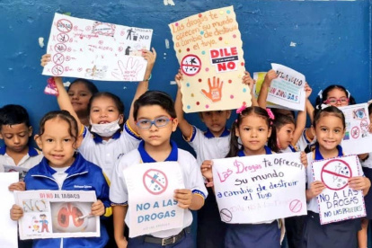 Los estudiantes muestran sus mensajes contra el consumo de drogas.