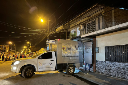 Un carro de la Policía forense llegó a la vivienda para el levantamiento de los cuerpos.