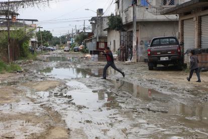 En la cooperativa 5 de Junio, niños y adultos tienen que cruzar las calles saltando para evitar caer en aguas empozadas.