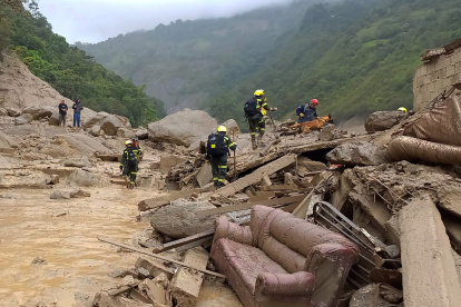 Fotografía cedida por la Policía Nacional de Colombia que muestra a miembros de organismos de rescate en la zona donde ocurrió una avalancha en Quetame, Cundinamarca (Colombia).